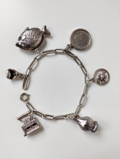 Prachtige vintage design armband in zeer goede staat met unieke bedeltjes. Staat prachtig om de pols met en zet een uniek tijdsbeeld neer. Goed werkende sluiting met een vaste veiligheidsketting  Bedels: - Vis - Boxhandschoen - Strijkijzer - Wijnfles - Schorpioen - Wilhelmina Kwartje / 25 cent (gulden) Gewicht volledige armband: 27.67 gram Lengte armband: 18,8 cm Zorgvuldige verpakking en verzekerde verzending Antique Charm Bracelet With Vintage Charm, Antique Style Bracelets With Dangling Charms As Gift, Antique Bracelets With Dangling Charms As Gift, Antique Bracelets With Dangling Charms For Gift, Antique Metal Bracelet With Charms, Antique Jewelry With Dangling Charms For Collectors, Vintage Jewelry With Jubilee Bracelet For Collectors, Antique Charm Bracelet With Vintage Charm As Gift, Antique Charm Bracelet Gift