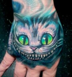 a hand painted with a cat's face and green eyes is seen in this image