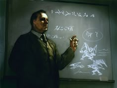 a man standing in front of a whiteboard with writing on it and holding a pen