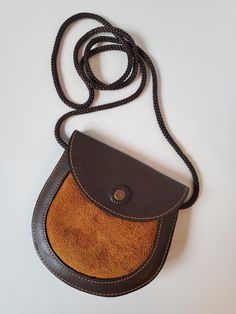 "This gorgeous brown vintage bag is made with real leather and suede! It's perfect for any fan of western wear or anyone who needs a small bag! Buy it for yourself or as a gift! Perfect for small items such as makeup, cell phone, tobacco or cigarettes! We love this unique leather handmade bag Snap closure and in great vintage condition Height: 5\" Length: 5\" at longest point Width: 2.5\" fully open Strap: 40\" long US SHIPPING  FREE International shipping, please see the rate Please add our shop as a ❤ favorite so you can find us again! Our website is minxandonyx.com Www.facebook.com/minxandonyx @minxandonyx follow us on Instagram Thank you for shopping at Minx and Onyx Vintage!" Retro Brown Saddle Bag For Daily Use, Brown Pouch Shoulder Bag With Coin Pocket, Brown Leather Saddle Bag With Phone Pocket, Vintage Brown Satchel With Mobile Phone Bag, Brown Crossbody Shoulder Bag With Coin Pocket, Vintage Brown Pouch Satchel, Brown Vintage Pouch Satchel, Brown Soft Leather Saddle Bag Shaped As Pouch, Brown Soft Leather Pouch Saddle Bag