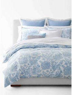 a bed with blue and white comforters on it