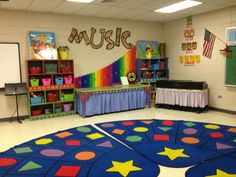 an empty classroom with colorful rugs and bookshelves