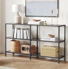 a shelf with books and other items on it in front of a wall mounted mirror