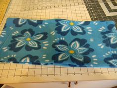 a blue and white flowered cloth is on a cutting board next to a pair of scissors