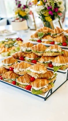 several trays filled with sandwiches on top of a table