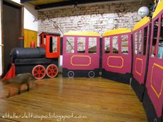 a dog laying on the floor in front of a fake train