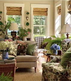 a living room filled with lots of furniture and flowers in vases on the table