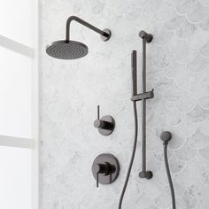 the shower head and handset are shown in this bathroom with white marble walls and flooring