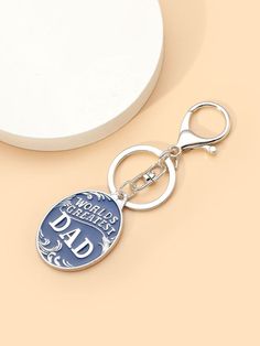 a keychain with the word dad on it sitting next to a round object