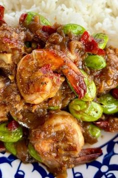 a blue and white plate topped with rice and shrimp