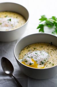 two white bowls filled with soup and topped with an egg