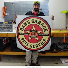 a man holding up a sign that says dad's garage all service on it