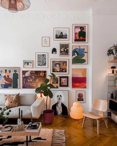 a living room filled with furniture and lots of pictures on the wall above it's coffee table