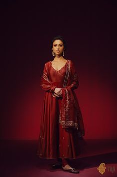 "A classic maroon full-sleeved\u00a0anarkali\u00a0with an\u00a0angrakha style neckline, punctuated with aari embroidery on the bodice, sleeves, and a shower of floral bootis\u00a0on the flared ends. Paired with a plain churidar\u00a0and an ornately hand-embroidered organza dupatta.\n\n\n\n Color\u00a0-  A\u00a0rich shade of\u00a0Maroon\n\n\n Fabric\u00a0-\u00a0Anarkali in pure Chanderi\u00a0silk, churidar in\u00a0pure silk, dupatta in pure organza silk\n\n\nCollection Note\u00a0-\u00a0Distinguished by its creative\u00a0rendition of designs that\u00a0reflect a heritage steeped in artistry, the Tilfi Kala collection draws inspiration from the\u00a0mesmerising\u00a0intricacy\u00a0of old Mughal miniature art and architecture, bringing\u00a0it to life on textiles through masterful craftsmanship Angrakha Style Kurti Straight, Banarasi Anarkali, Angrakha Style Kurti, Plain Anarkali, Maroon Anarkali, Mughal Miniature, Suits For Women Indian, Anarkali Designs, Maroon Suit