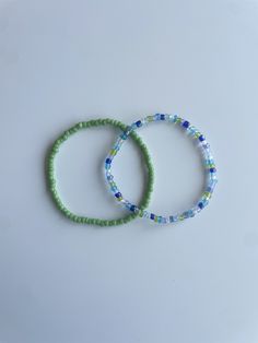 Stretchy bracelet set (2) - multi-blue green bracelet, light green bracelet These bracelets come in a set of two. They are meticulously handmade with seed beads and stretchy string. The durable bracelets are all triple knotted and glued shut. DISCLAIMER ON RETURN/EXCHANGE POLICY ~ Slightly mis-shaped bracelets due to knotting of the stretchy string is NOT INCLUDED in the return/exchange policy ~ Stretched out bracelets due to use over time is NOT INCLUDED in the return/exchange policy ~ Only broken beads or broken string within the return/exchange policy window ARE INCLUDED in the return/exchange policy Cheap Handmade Blue Beaded Bracelets, Adjustable Green Beaded Bracelets For Friendship, Adjustable Green Beaded Bracelets With Round Beads, Green Bracelets With Colorful Beads For Beach, Adjustable Green Beaded Bracelets, Green Bracelets For Friendship, Green Hand-strung Friendship Bracelets For Beach, Green Hand-strung Friendship Bracelets, Adjustable Green Beaded Bracelet