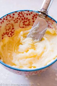 a spoon in a bowl filled with mashed potatoes