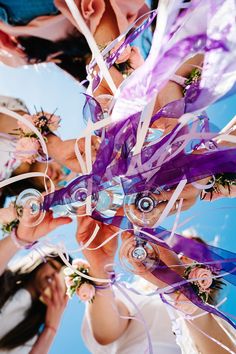 a group of people standing around each other holding something in their hands with ribbons on them