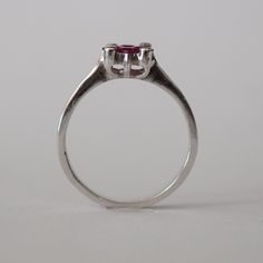 This piece is a wonderful solid white gold ring. It is also a new vintage- made before 2001. The ring is brilliantly decorated with 4 genuine princess cut Chantaburi rubies from Thailand in the middle and on the sides are 4 tiny round cut natural diamond. Only one left- once its gone its gone! Product Details: Metal: 18k Solid Gold Metal Color: White Gold Gold weight: 3.10 grams Ruby: Natural, princess cut, 0.65 carats Diamonds: Natural, round faceted cut, 0.08 carats Band Width: 7 mm #Customiza Classic Ruby Ring For Promise With Prong Setting, Classic Ruby Rings With Round Cut, Vintage Ruby Rings With Polished Finish, Classic White Gold Ruby Ring With Round Cut, Classic Round Ruby Promise Ring, Classic Promise Ruby Solitaire Ring, Classic Solitaire Ruby Promise Ring, Classic Solitaire Ruby Ring For Promise, Classic Sapphire Ring Gift