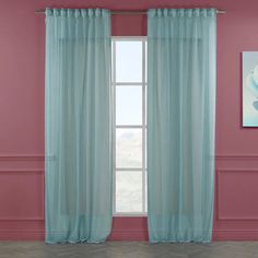 a room with pink walls and blue curtains