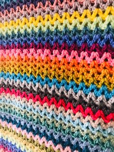 a multicolored crocheted blanket laying on top of each other