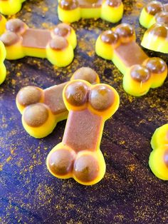 there are many candies shaped like teddy bears on the table with yellow and brown frosting