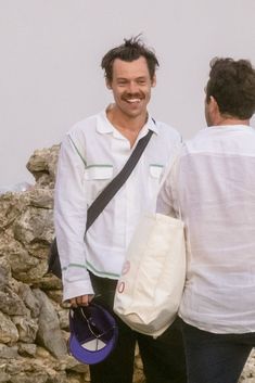 two men standing next to each other near rocks