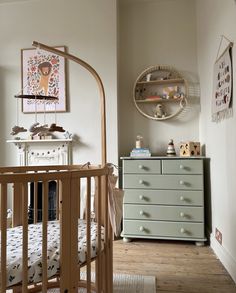 a baby's room with a crib, dresser and bed in the corner