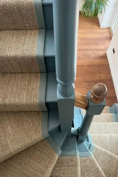 an overhead view of the carpeted stairs and handrails in a home with wood flooring