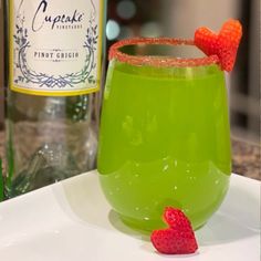 a green drink with strawberries on the rim