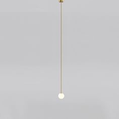 a white and gold light fixture hanging from a ceiling in a room with gray walls