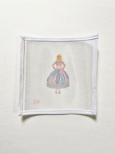 a cross stitched picture of a woman in a pink dress on a white background