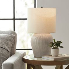 a table with a lamp on it next to a couch