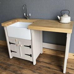 a white sink sitting under a wooden counter top next to a stove and dishwasher