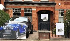 a car parked in front of a building with a large poster on it's side