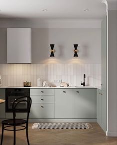 a modern kitchen with white cabinets and black chairs in the center, along with an area rug on the floor