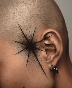 a man's head with an ear piercing on it and stars in the middle