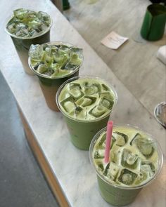 three cups filled with ice cream sitting on top of a counter next to each other