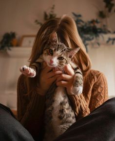 a woman holding a cat in her arms