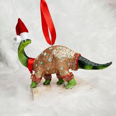 an ornament in the shape of a dinosaur with a santa hat on it's head