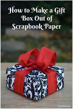 a black and white gift box with red ribbon on it, the text how to make a gift box out of scrapbook paper