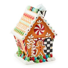 a gingerbread house ornament with candy and candies on the outside, in front of a white background