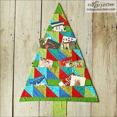 a quilted christmas tree with pictures on it