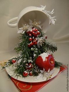 a white plate topped with an apple next to a cup filled with snow covered apples