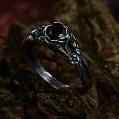 a black diamond ring sitting on top of a rock