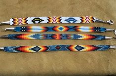 three beaded bracelets sitting next to each other on top of a brown surface