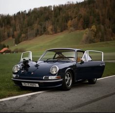 a blue sports car is parked on the side of the road with its hood up