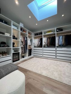 a large walk in closet with lots of clothes