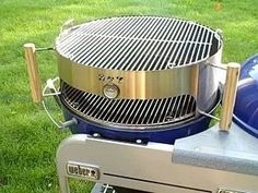 a large grill sitting on top of a green grass covered field next to a blue ball