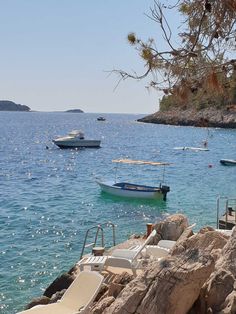 there are many boats in the water and one boat is sitting on the rocks near the shore