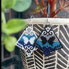 two beaded earrings hanging from a potted plant